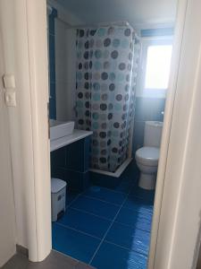 a blue bathroom with a toilet and a shower at Irida's House in Xylokastro
