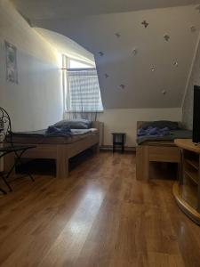 a large room with two beds and a window at Penzion Bilina in Teplice
