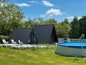 a house with a swimming pool and a group of chairs at STORY GLAMPING POLOVRAGI in Racoviţa