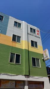 a multicolored building with the words guest house on it at MK Guesthouse in Busan
