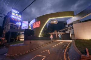 een nachtzicht op een gebouw met neonborden bij Guest Motel- Zhongli Branch in Pingzhen