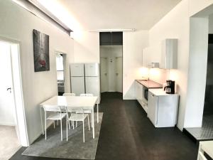 a kitchen and dining room with a white table and chairs at B@Home Apartments in Sanem +37 photos