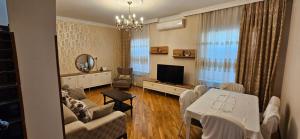 a living room with a table and a television at Casa Villa in Baku