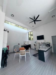 a living room with a ceiling fan and a table and chairs at CasaView Island Marang in Marang