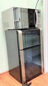 a microwave oven sitting on top of a refrigerator at Apto Turismo da Serra in Teresópolis