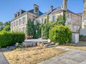 an old stone house with bushes in front of it at Maison de maître, Piscine privée, 4 suites in Nersac