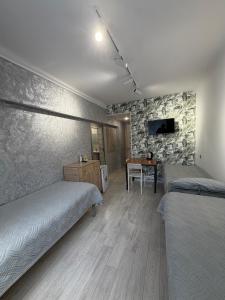 a bedroom with two beds and a table in it at 7 Nebo in Almaty