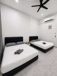 a bedroom with two beds and a ceiling fan at CasaView Island Marang in Marang