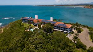 an aerial view of a building on a hill next to the ocean at Hotel Pontal de Ubu in Anchieta