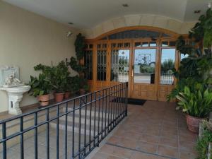 a hallway with potted plants and a wooden door at HOTEL RURAL HIDALGO in Torreperogil +8 photos