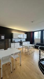 a living room with tables and a kitchen and a couch at B@Home Apartments in Sanem
