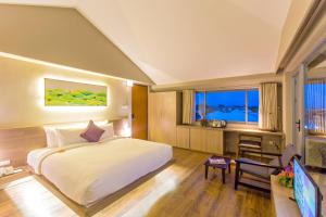 a bedroom with a bed and a desk and a television at Mulberry Collection Silk Eco in Hoi An