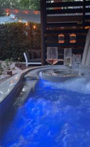 a table with glasses of wine in a swimming pool at Berg en Bos Suite met luxe jacuzzi in Apeldoorn