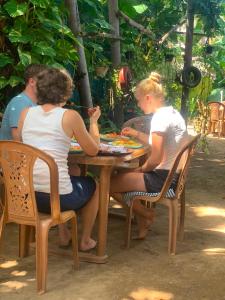 a group of people sitting at a table at Green House Holiday Villa in Trincomalee