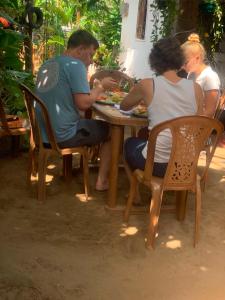 a group of people sitting at a table eating food at Green House Holiday Villa in Trincomalee +41 photos