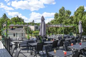 a patio with tables and chairs and umbrellas at Teatterihotelli Riihimäki in Riihimäki