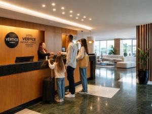 a family standing at a counter in a hotel lobby at Vértice Indalo Almería in Almería +22 photos