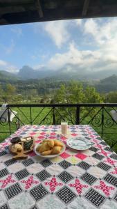a table with a plate of food on a checkered table cloth at Kulla e Vjetër ,Vermosh in Vermosh +8 photos