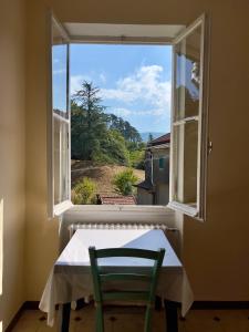 a window with a table and a chair in a room at Govinda in Pontinvrea