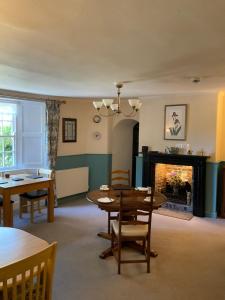 a living room with a table and a fireplace at Stratton Gardens in Bude