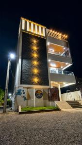 a building with a tower with lights on it at night at Graps Ocean Stay in Chīrāla
