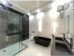 a bathroom with a black tub and a glass shower at Rivona Hotels & Suites in Uyo
