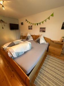 a bedroom with a bed with a green banner on the wall at Moosinest-Birkenzimmer in Schonach