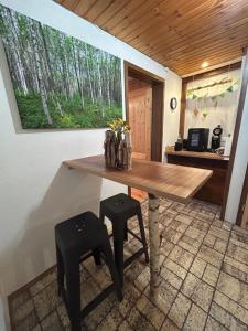 a kitchen with a wooden table and two stools at Moosinest-Birkenzimmer in Schonach