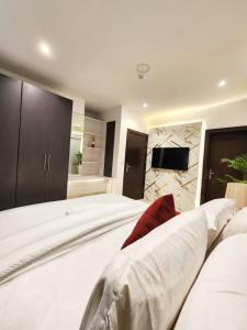 a large bedroom with a large white bed with a tv at Rivona Hotels & Suites in Uyo +18 photos