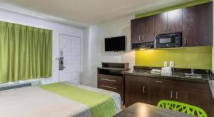 a small hotel room with a bed and a kitchen at Studio 6 Buttonwillow, CA in Bowerbank +12 photos