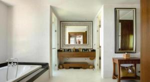a bathroom with a tub and a sink and a mirror at Pimalai Resort & Spa in Ko Lanta