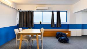 a room with a table and chairs and a window at Destiny Hostel Pattaya in Jomtien Beach