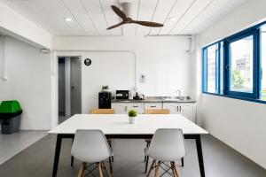 a dining room with a white table and chairs at Destiny Hostel Pattaya in Jomtien Beach