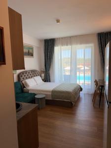 a bedroom with a bed and a couch and a window at Studio Blaxy Mihnea in Douăzeci şi Trei August +66 photos
