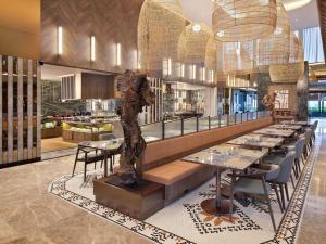 a restaurant with a table and a statue in the middle at Mercure Pangkalan Bun in Pangkalan Bun
