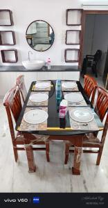 a dining room table with chairs and a mirror at Graps Ocean Stay in Chīrāla