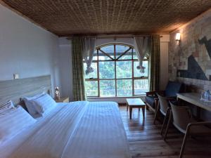 a bedroom with a large bed and a window at Ikoro Hotel in Kisoro