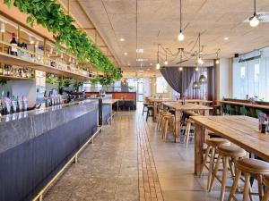 a restaurant with wooden tables and chairs and plants at Novotel Melbourne Preston in Melbourne