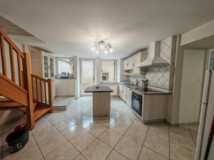 a kitchen with white cabinets and a table in it at Renée-Sens in Châteauvillain +7 photos