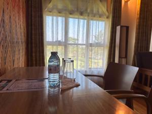 a bottle of water sitting on top of a wooden table at Ikoro Hotel in Kisoro