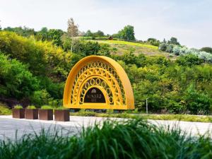 a large yellow arch in the middle of a park at Minaro Hotel Tokaj - MGallery Collection - Adults Only in Tokaj +79 photos