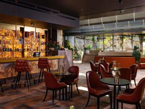 a restaurant with tables and chairs and a bar at Minaro Hotel Tokaj - MGallery Collection - Adults Only in Tokaj