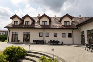 a building with tables and chairs in a courtyard at Dom Weselny Perła Warmii in Lidzbark Warmiński +23 photos