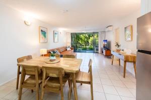 a kitchen and living room with a wooden table and chairs at Azure Beach Retreat 2 in Rainbow Beach