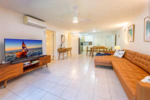 a living room with a couch and a flat screen tv at Azure Beach Retreat 2 in Rainbow Beach +19 photos