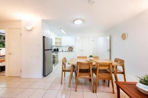 a kitchen and dining room with a wooden table and chairs at Azure Beach Retreat 2 in Rainbow Beach