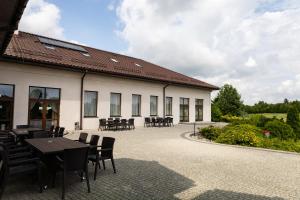 a building with tables and chairs in a courtyard at Dom Weselny Perła Warmii in Lidzbark Warmiński