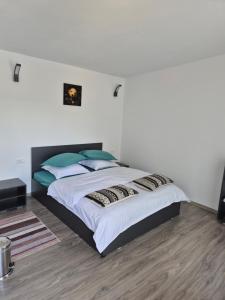 a bedroom with a large bed with blue pillows at Gusturi din Livadă in Costeşti-Vîlsan