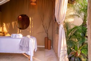 a bedroom with a white bed and a plant at Pousada Vina in Jericoacoara +32 photos