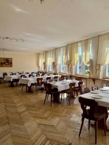 a dining room with tables and chairs and windows at Hotel Gästehaus Altena in Altena